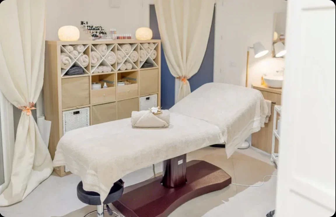 La cabine de soin, lumineuse et cosy, avec sa table chauffante et ses serviettes roulées